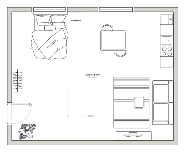 Floor plan of a studio with the bed under the window and the living furniture grouped on the opposite side